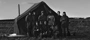 Archive image showing some of the first jackets worn by a group standing in front of a tent