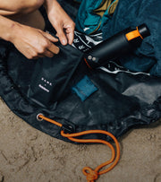 Changing mat bag with the DAME collaboration product and ocean bottle sitting on it